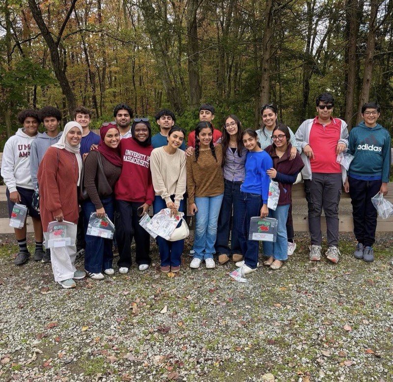 ICB Youth Group members on an outdoor trip, holding bags of apples